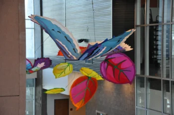 Colorful suspended kinetic artwork in an interior atrium.