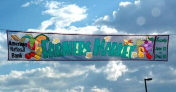 Harmex Market banner suspended outdoors.